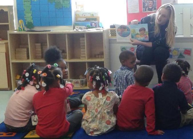 UDM Business major Anna Mindling reads Doc McStuffins with the kids at Emmanuel