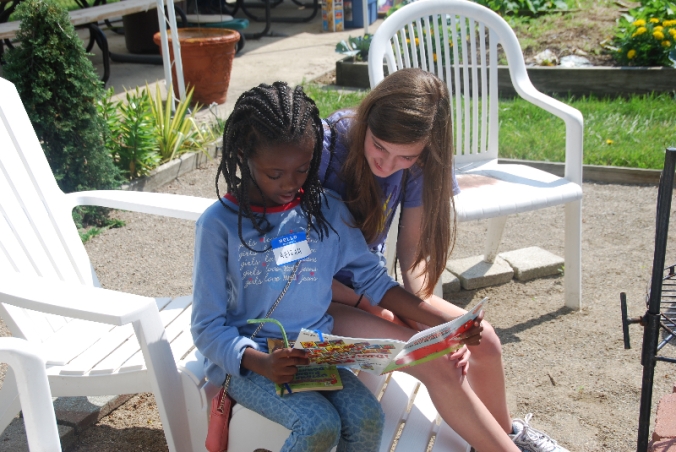A camper and counselor read at the Minock Park Summer in the City Camp.